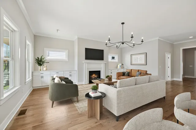 a living room with furniture a fireplace and a chandelier