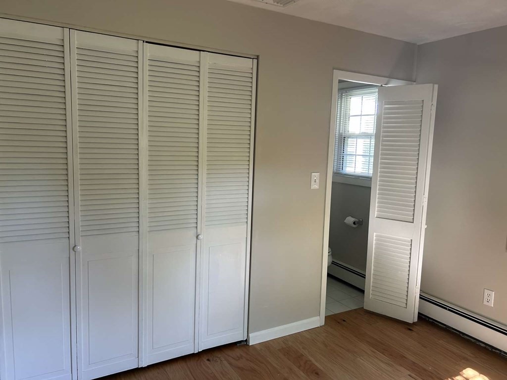 19 Merrill Drive Framingham, MA 01701 - Photo 5 of 18 an empty room with wooden floor closet and windows