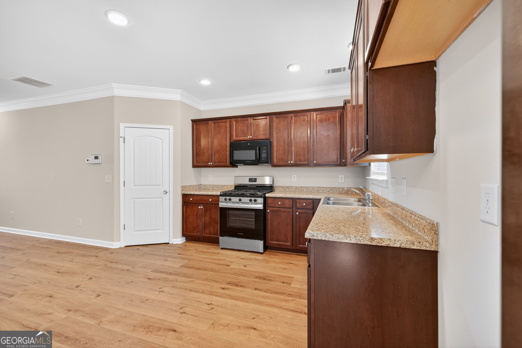 1734 Snapping Court Winder, GA 30680 - Photo 11 of 35 a kitchen with granite countertop a refrigerator stove top oven and sink