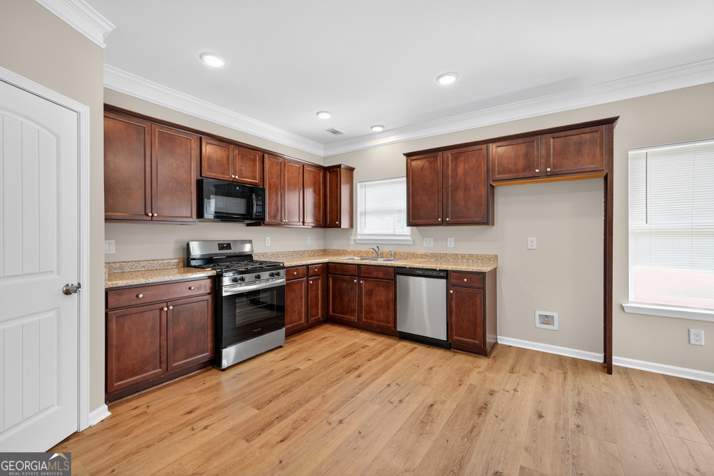 1734 Snapping Court Winder, GA 30680 - Photo 12 of 35 a kitchen with stainless steel appliances granite countertop wooden cabinets a stove a sink and a refrigerator