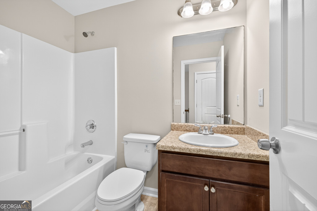 1734 Snapping Court Winder, GA 30680 - Photo 23 of 35 a bathroom with a granite countertop sink a toilet and shower