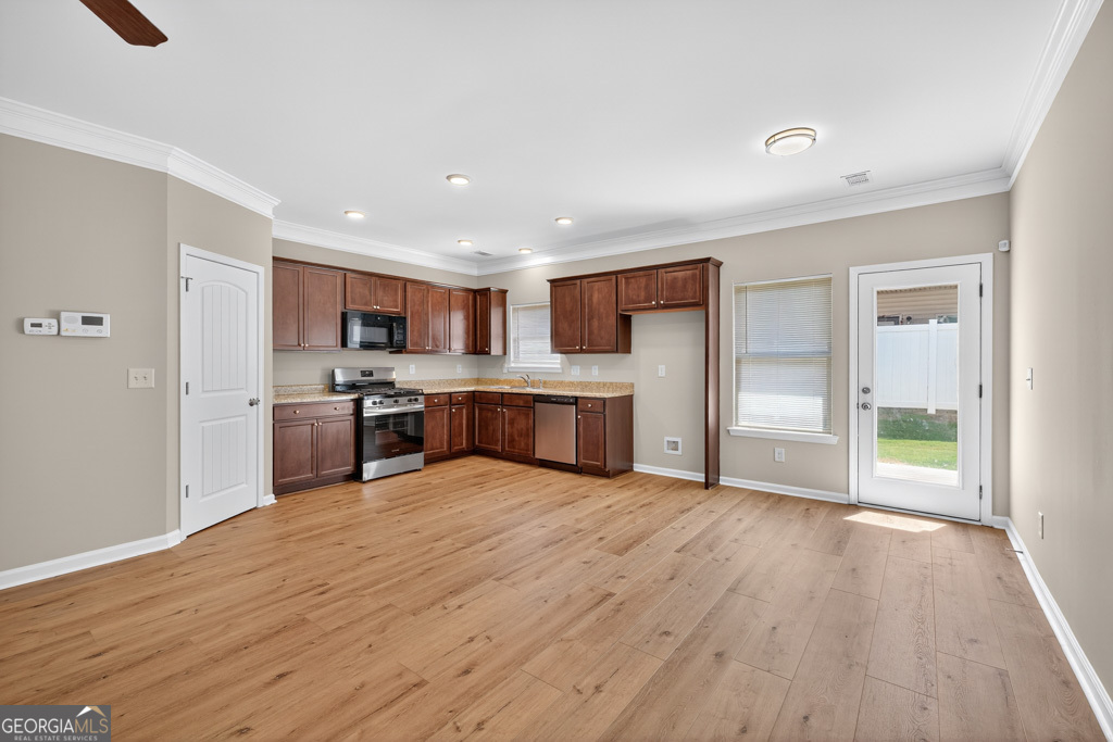 1734 Snapping Court Winder, GA 30680 - Photo 7 of 35 a large kitchen with stainless steel appliances granite countertop a stove a sink and a refrigerator