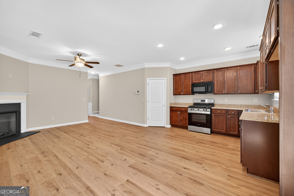 1734 Snapping Court Winder, GA 30680 - Photo 10 of 35 a kitchen with stainless steel appliances kitchen island granite countertop wooden cabinets a stove a sink and dishwasher