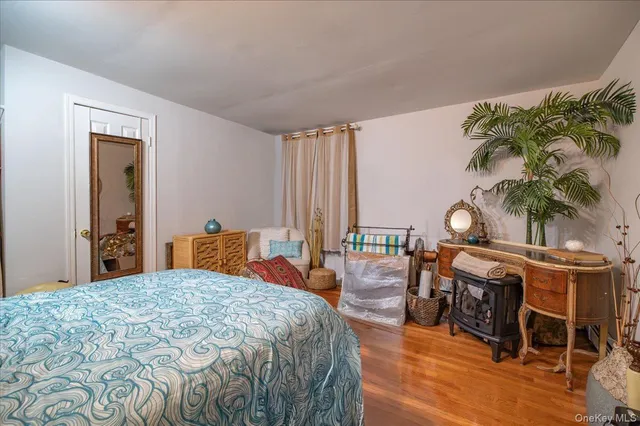 a bedroom with a bed and a chair with the wooden floor