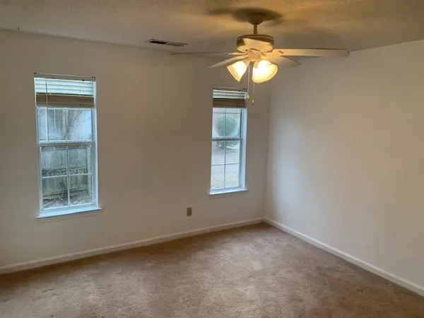 a view of an empty room with a fireplace and a window