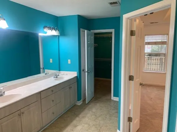 a spacious bathroom with a double vanity sink and a mirror