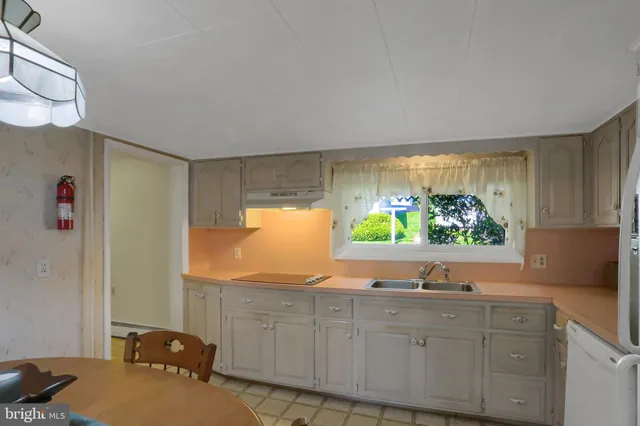 a kitchen with stainless steel appliances granite countertop a sink a window and a counter space