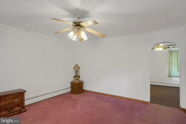 an empty room with windows and ceiling fan