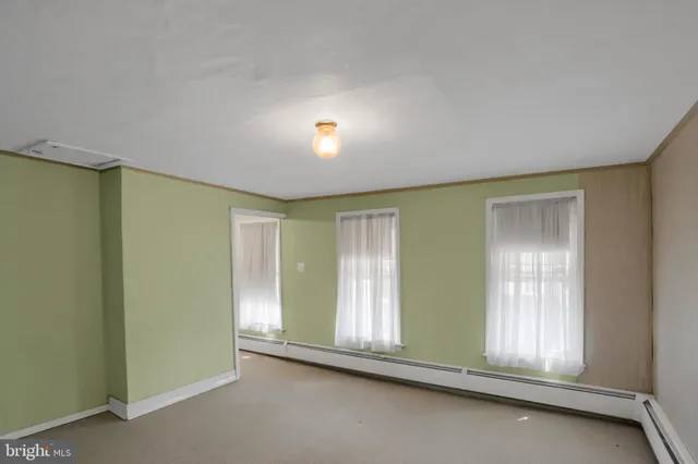 an empty room with closet and windows