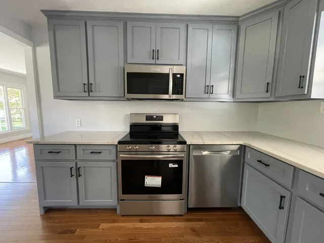 a kitchen with a refrigerator sink and cabinets