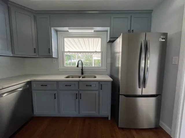 a kitchen with stainless steel appliances granite countertop a stove cabinets and wooden floor