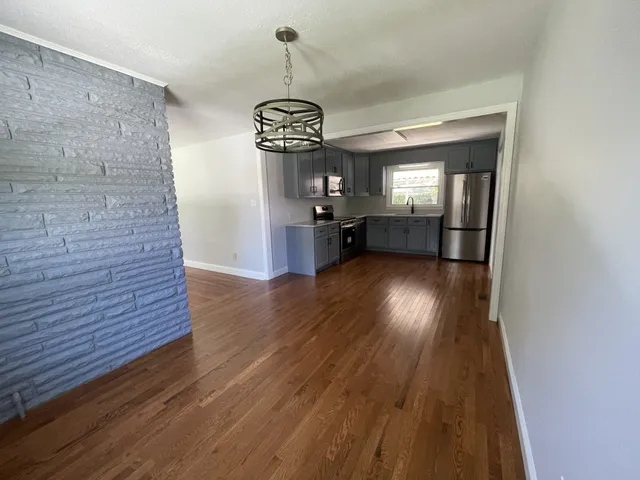 a kitchen with stainless steel appliances granite countertop a stove a microwave and a hard wood floors