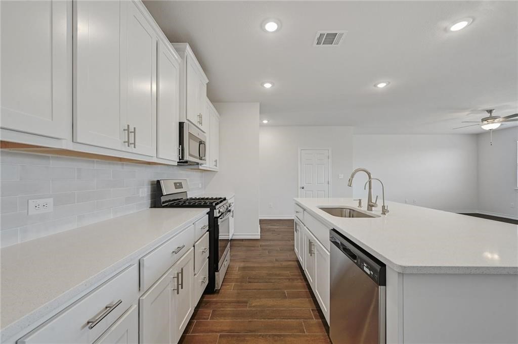 806 Pepperbark Loop Buda, TX 78610 - Photo 11 of 39 a kitchen with sink a stove and cabinets