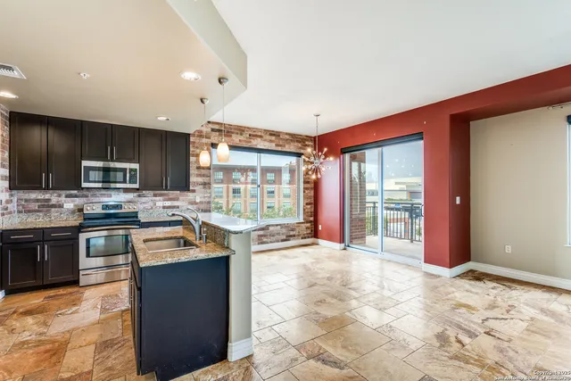 a kitchen with stainless steel appliances granite countertop a stove sink and cabinets