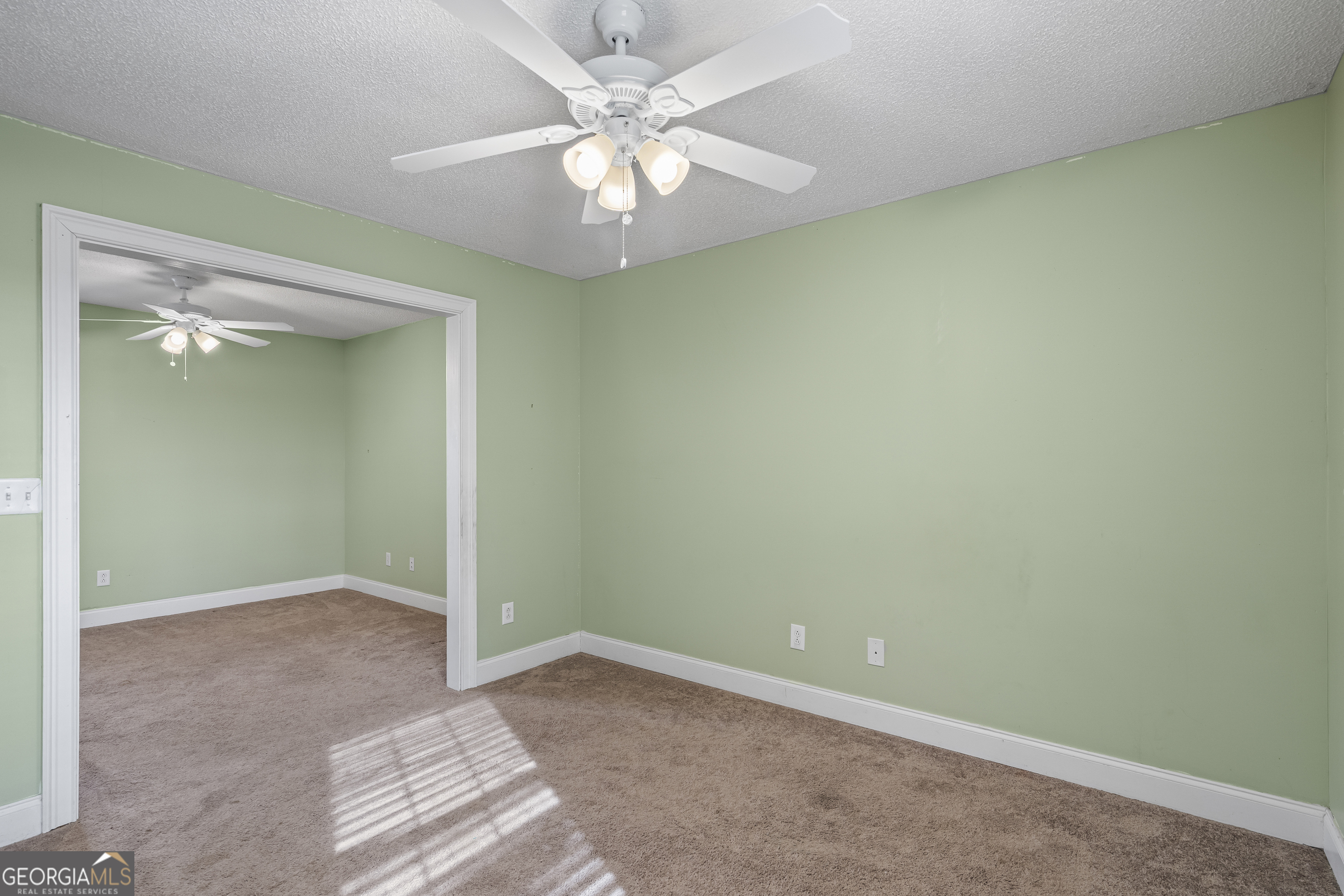 210 Blue Ridge Avenue Demorest, GA 30535 - Photo 22 of 74 an empty room with a chandelier fan and windows