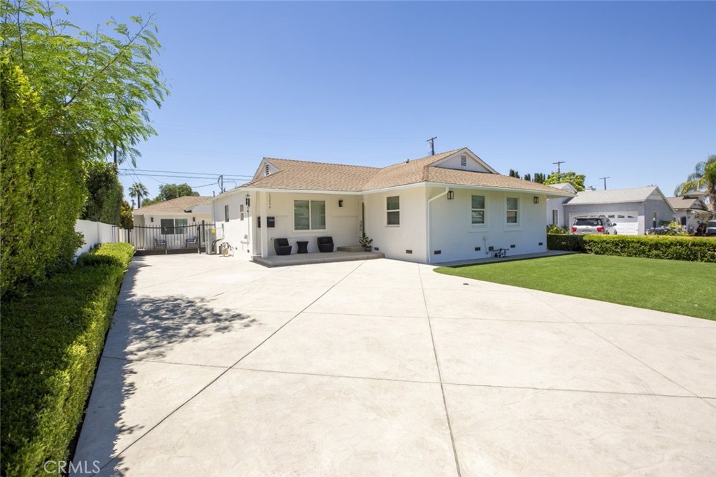 a view of house with yard and car parked