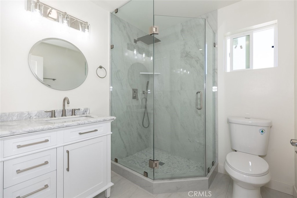 15254 Clymer Street Mission Hills, CA 91345 - Photo 17 of 26 a bathroom with a granite countertop toilet sink shower and mirror