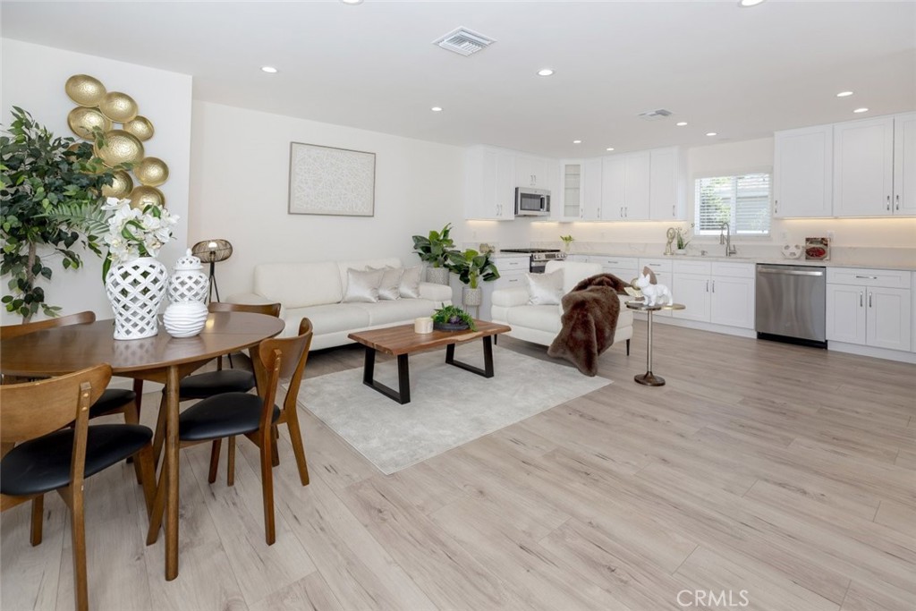 15254 Clymer Street Mission Hills, CA 91345 - Photo 4 of 26 a living room with furniture a dining table wooden floor and kitchen view