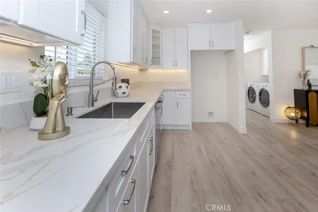 a kitchen with stainless steel appliances granite countertop a sink a stove top oven a counter space and cabinets