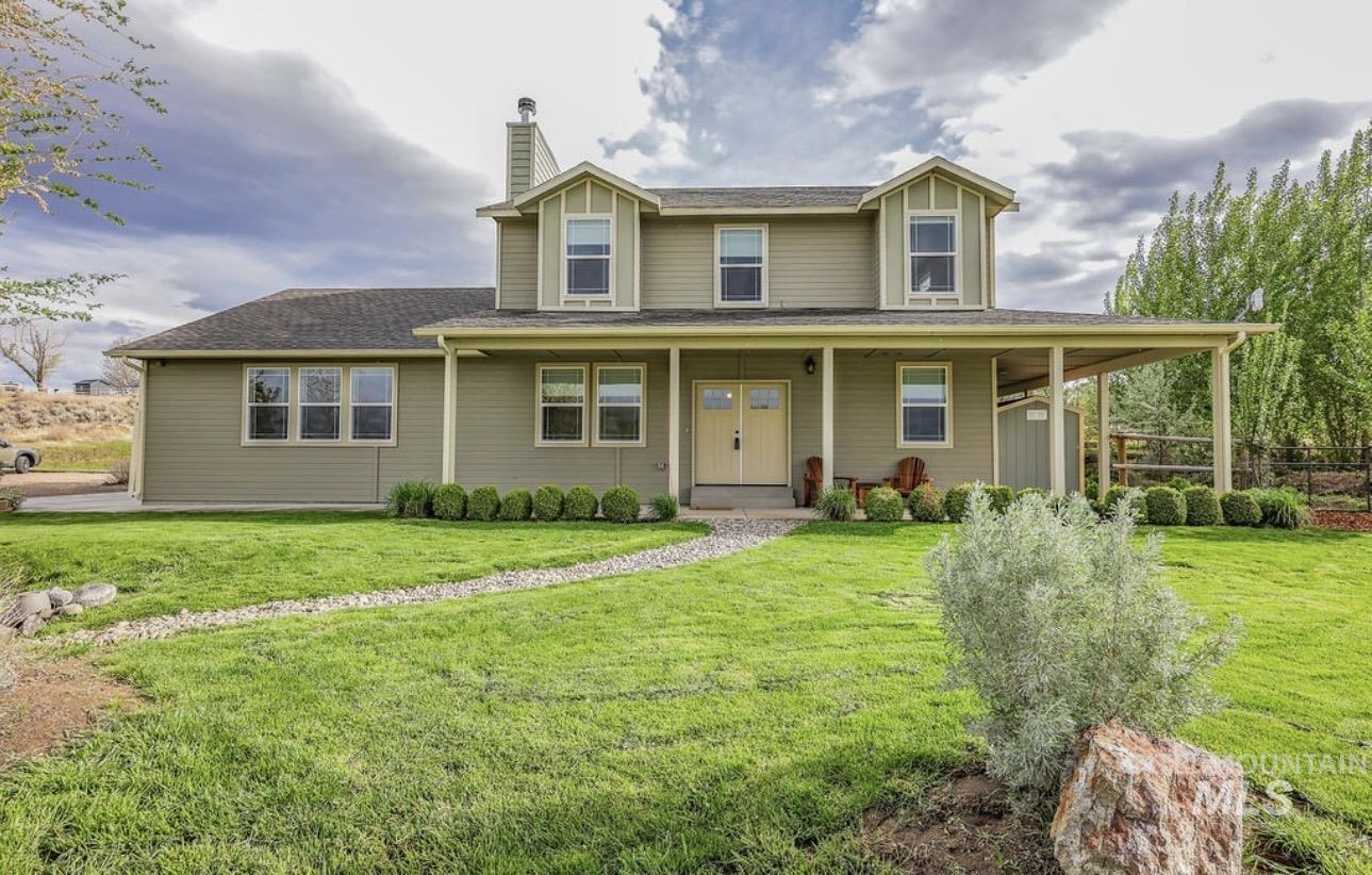 4517 Snake River Mesa Road Buhl, ID 83316 - Photo 1 of 1 View of front of home with a porch, a chimney, a front lawn, and roof with shingles