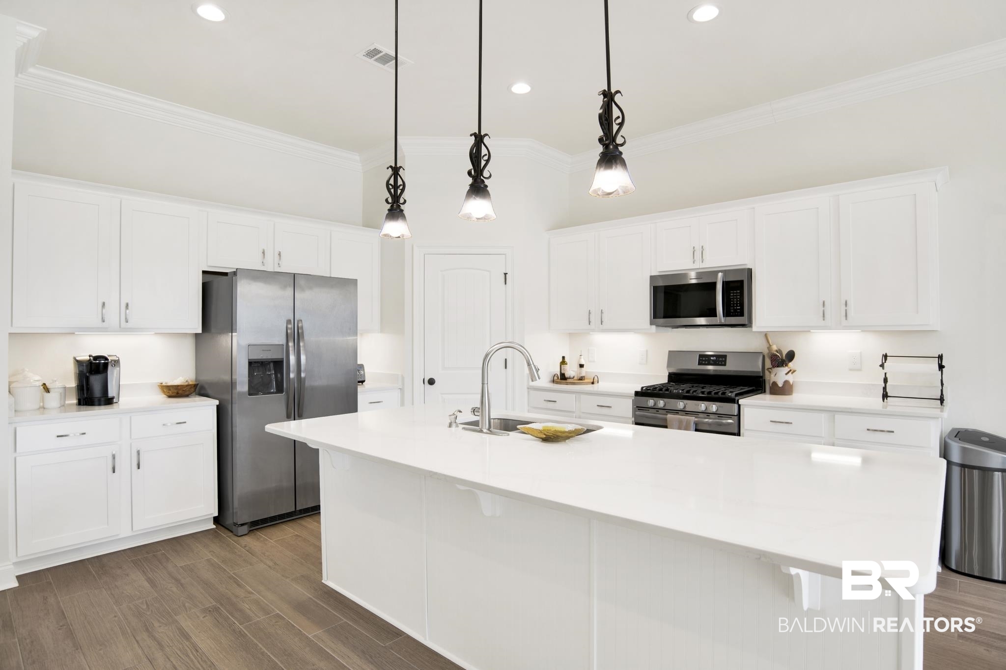 22258 Hibiscus Circle Foley, AL 36535 - Photo 9 of 26 Kitchen with wood finished floors, visible vents, appliances with stainless steel finishes, and ornamental molding