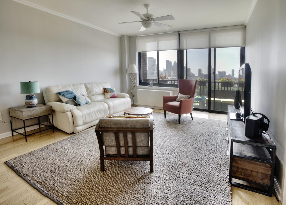 700 Grove Street, Unit 12J Jersey City, NJ 07310 - Photo 1 of 16 a living room with furniture and a fireplace