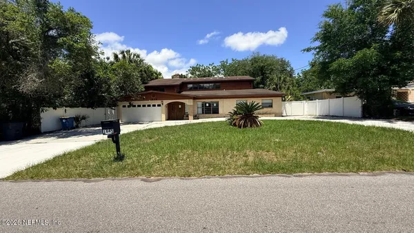 a view of a house with a yard and sitting area