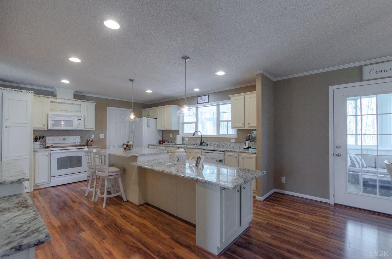 309 Lakeside Road Penhook, VA 24137 - Photo 5 of 61 a large kitchen with kitchen island a sink dishwasher a stove and a refrigerator with wooden floor