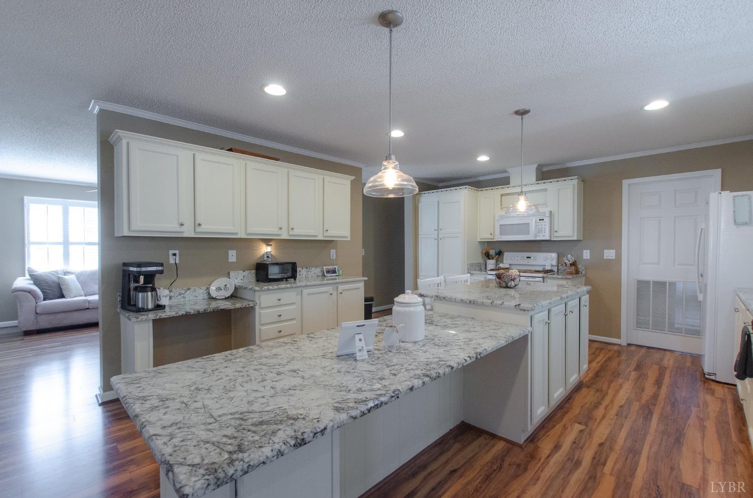 309 Lakeside Road Penhook, VA 24137 - Photo 7 of 61 a large kitchen with kitchen island a stove a sink dishwasher and wooden cabinets with wooden floor