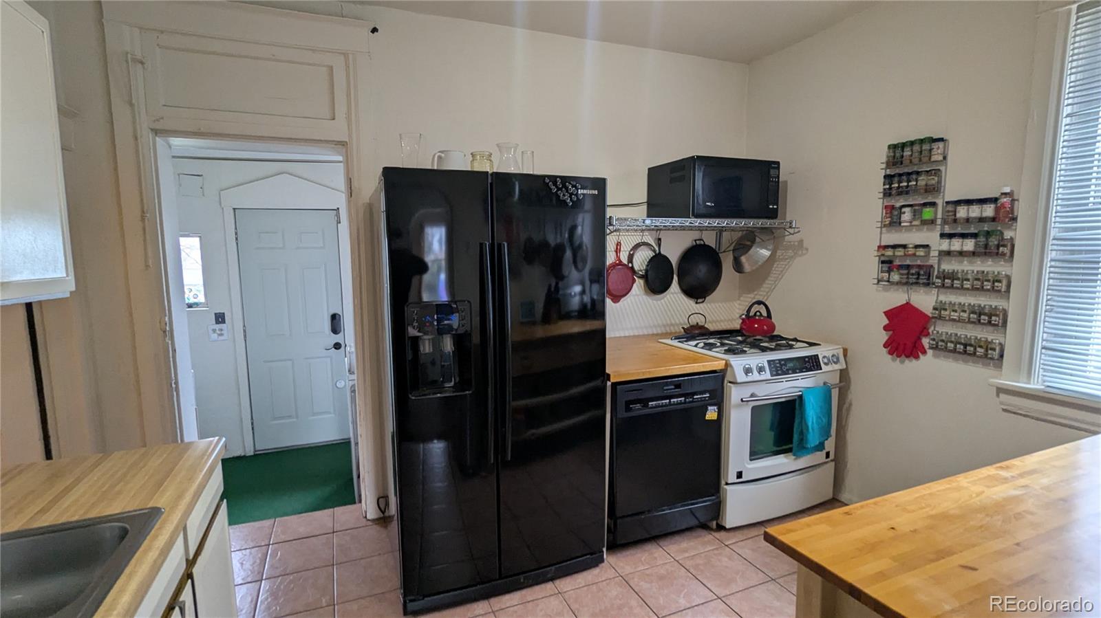 3924 Jason Street Denver, CO 80211 - Photo 15 of 26 a kitchen with stainless steel appliances granite countertop a refrigerator and a stove