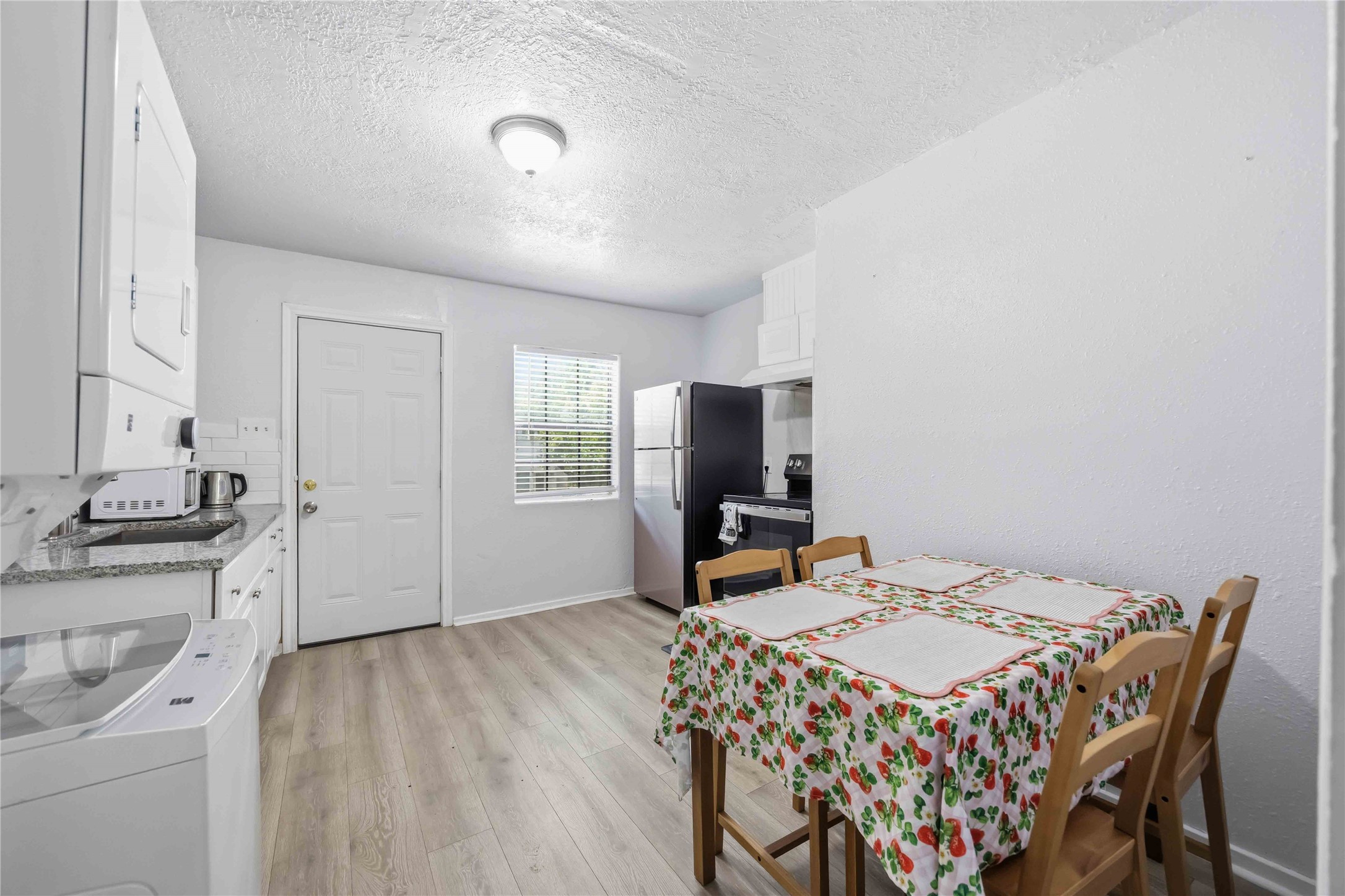 6726 Burkett Street Houston, TX 77021 - Photo 5 of 18 a open kitchen with stainless steel appliances a dining table and chairs with wooden floor