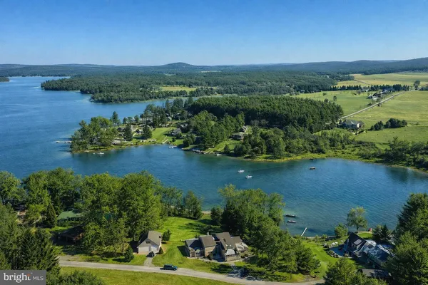 a kitchen with stainless steel appliances a sink a stove a refrigerator cabinets and a dining table