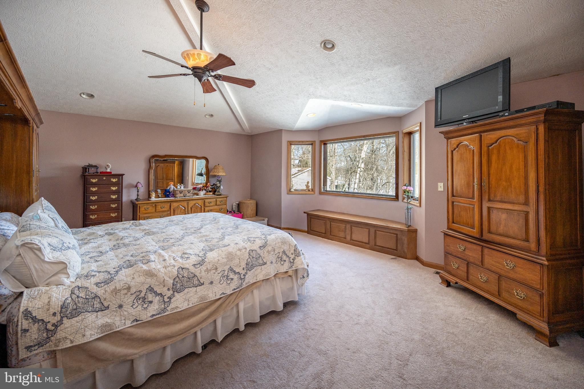 815 Chadderton School Road Oakland, MD 21550 - Photo 31 of 110 a spacious bedroom with a bed and a chandelier