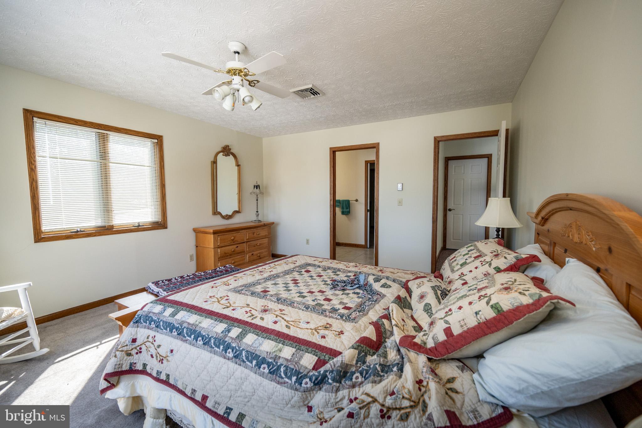 815 Chadderton School Road Oakland, MD 21550 - Photo 56 of 110 a bedroom with a bed and dresser with mirror