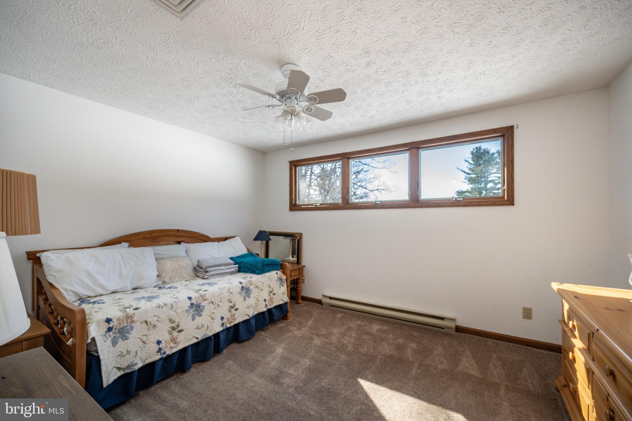 815 Chadderton School Road Oakland, MD 21550 - Photo 64 of 110 a bedroom with a bed a window and painting on the wall