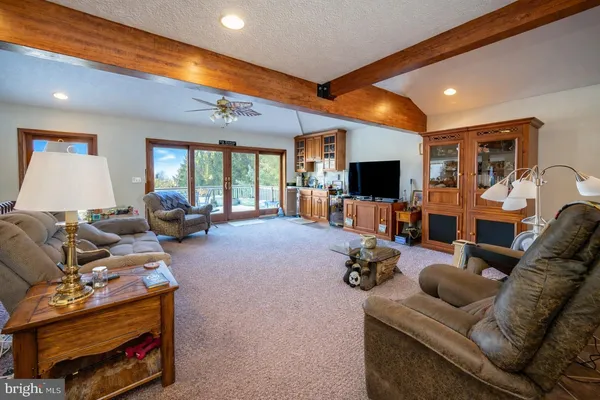 a kitchen with stainless steel appliances kitchen island granite countertop a table chairs in it and a sink