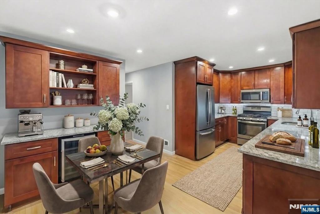 117 Sunset Key, Unit 117 Secaucus, NJ 07094 - Photo 2 of 22 a kitchen with stainless steel appliances granite countertop a refrigerator a stove a sink a dining table and chairs