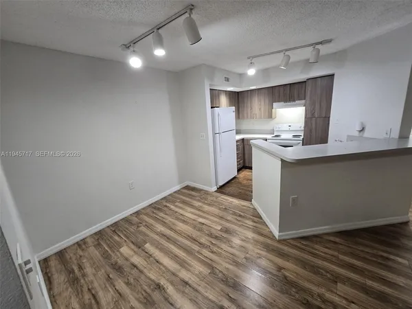 a view of a kitchen with a sink and wooden floor