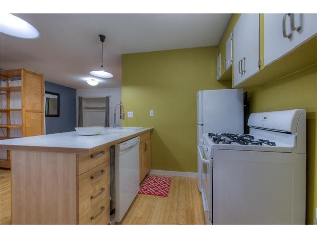 304 East 33rd Street, Unit 2 Austin, TX 78705 - Photo 7 of 12 a kitchen with a sink a refrigerator and wooden cabinets