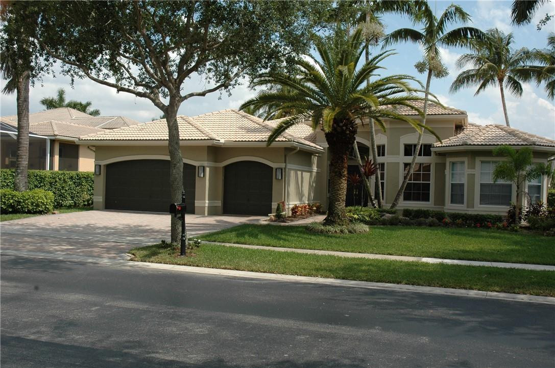 a front view of a house with a garden and trees