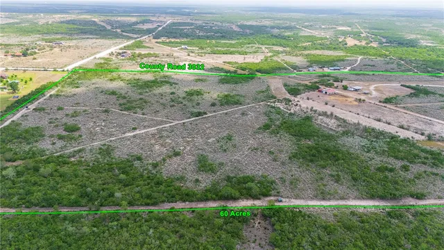 an aerial view of a houses with a yard and lake view