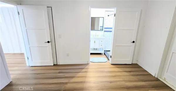 a view of empty room with wooden floor