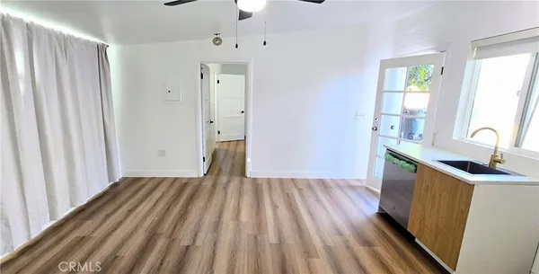 a room with a bed and a dresser next to a window