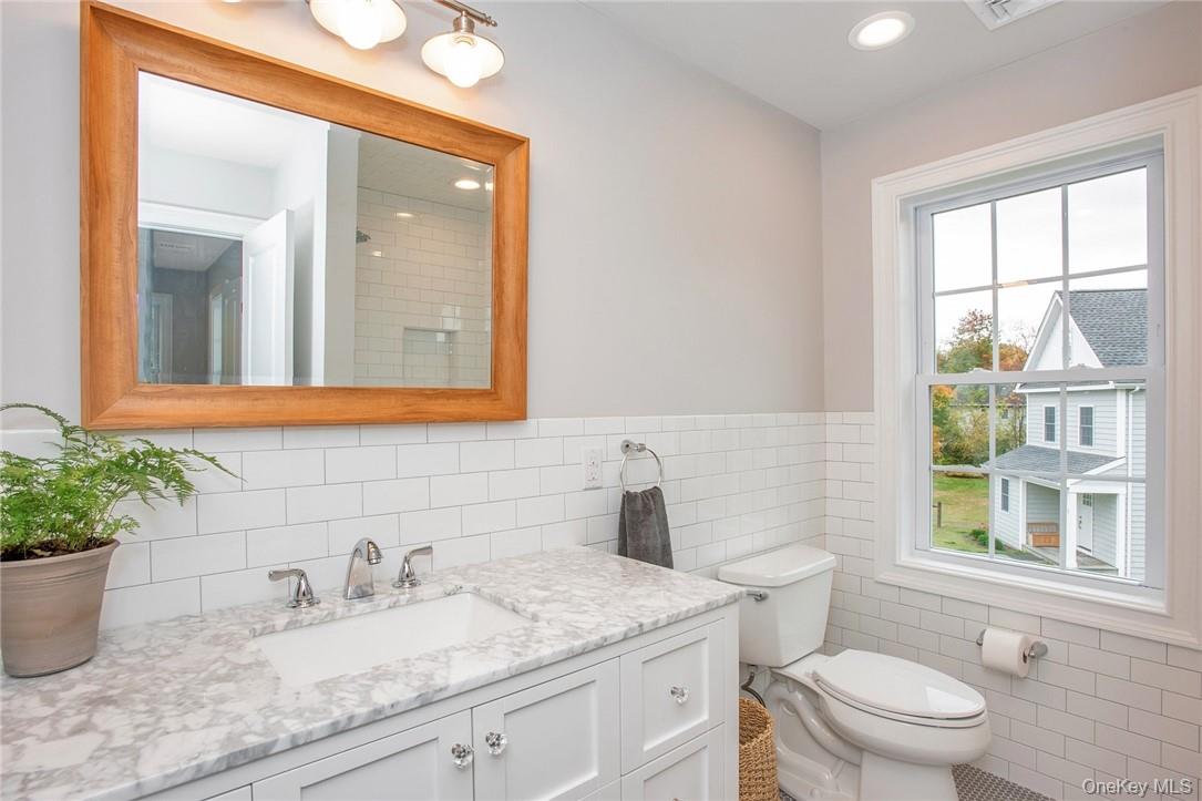 237 Tomahawk Street, Unit 3 Baldwin Place, NY 10505 - Photo 15 of 22 a bathroom with a granite countertop sink a large mirror and a toilet
