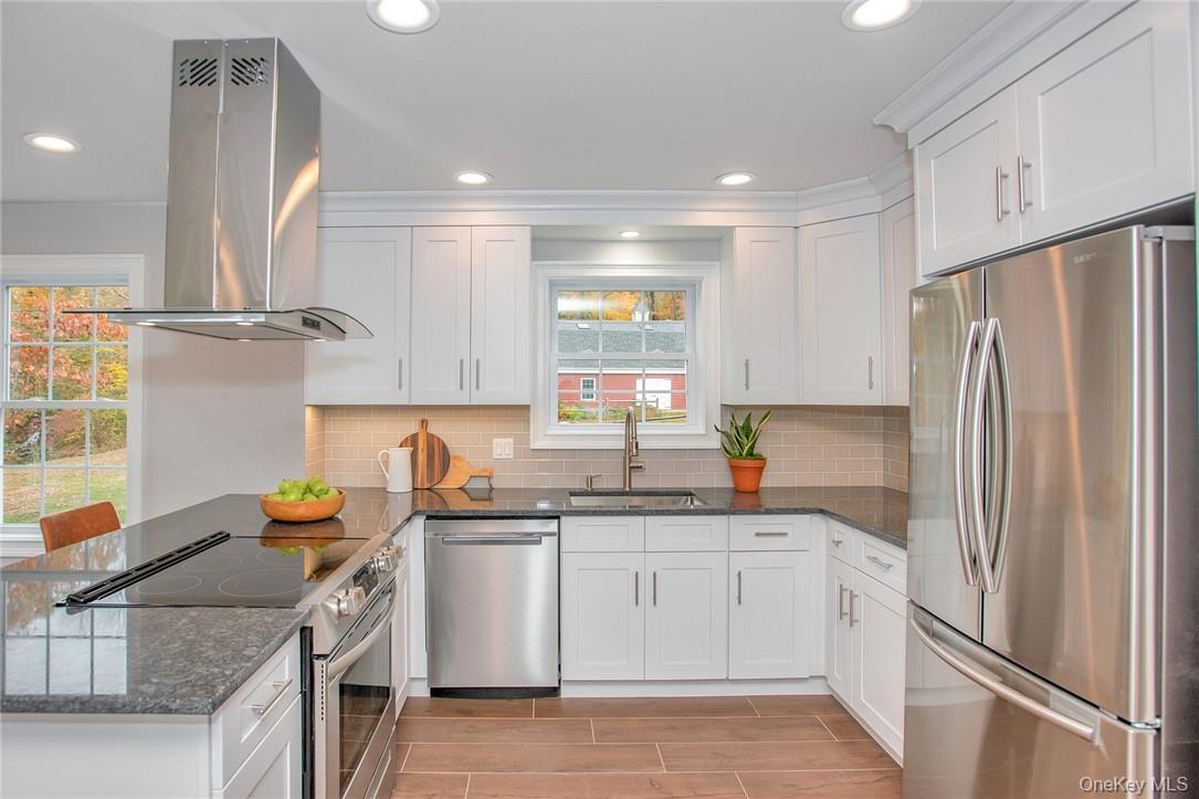 237 Tomahawk Street, Unit 3 Baldwin Place, NY 10505 - Photo 6 of 22 a kitchen with stainless steel appliances granite countertop a refrigerator sink and white cabinets