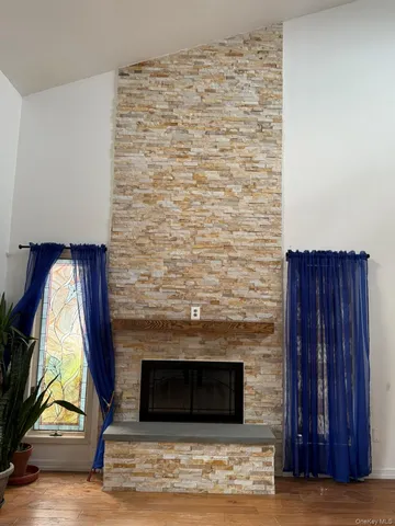 a view of empty room with wooden floor and fireplace