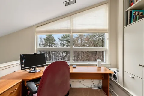 a view of a workspace with furniture and a window