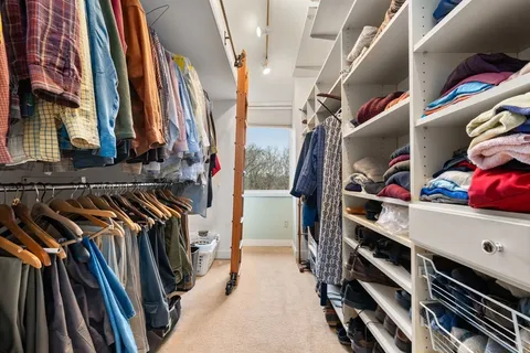 a view of walk in closet with clothes and shoes