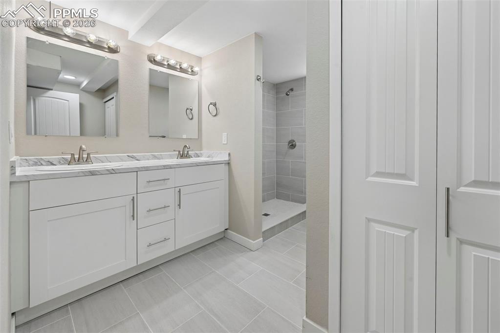 1901 Whitman Road Colorado Springs, CO 80910 - Photo 27 of 35 a spacious bathroom with a double vanity sink a mirror and a shower