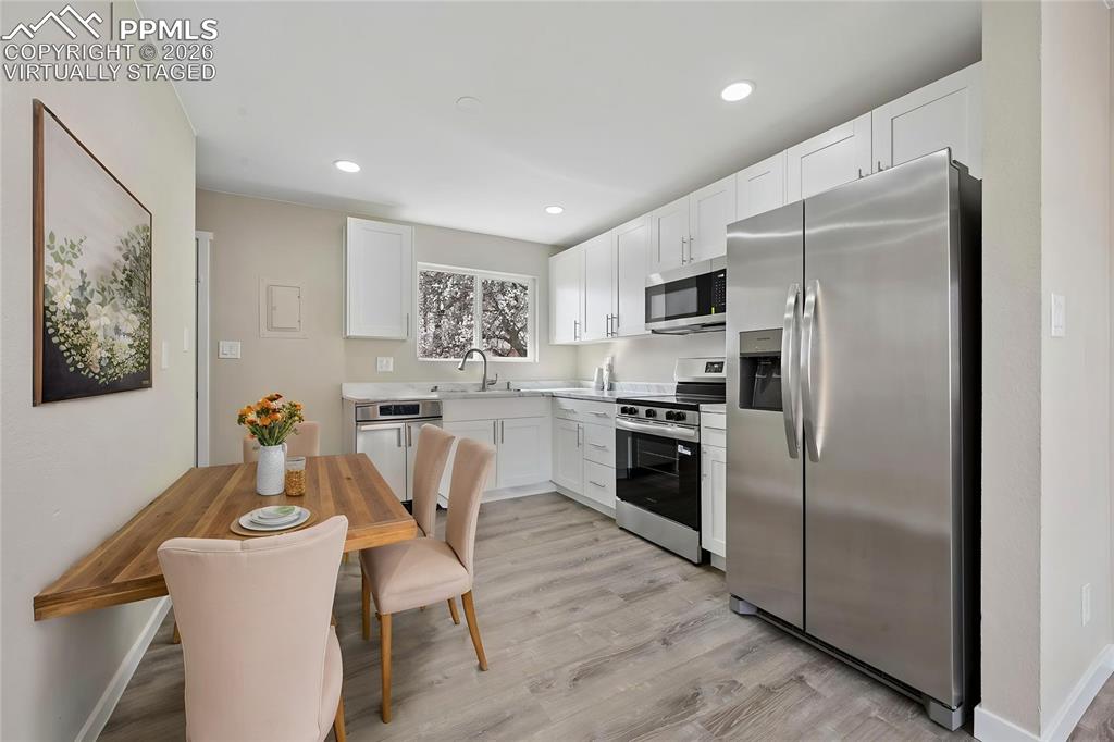 1901 Whitman Road Colorado Springs, CO 80910 - Photo 29 of 35 a kitchen with stainless steel appliances a refrigerator a stove a sink a dining table and chairs
